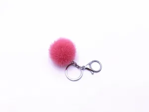 Detailed view of a soft pink faux fur pom pom keychain with a silver metal clasp