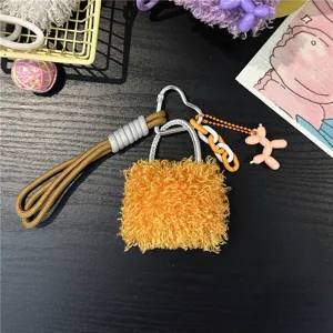 Close-up of a stylish orange fuzzy bag charm featuring a pink balloon dog accessory