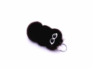 Detailed view of a cute dark brown plush caterpillar keychain with cartoon white-rimmed eyes