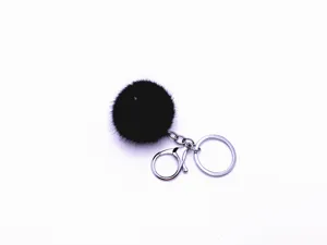 Close-up of a fluffy black fur ball keychain with silver-tone metal lobster clasp