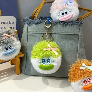Detailansicht von bunten, flauschigen Plüschpuppen-Schlüsselanhängern an einer Tasche