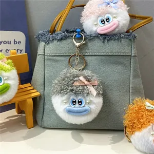 Hässlich-süßer Plüschpuppen-Schlüsselanhänger an einer Jeans-Tasche Detail