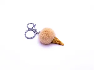 Close-up of cute plush ice cream cone keychain with soft pom pom and silver metal ring.