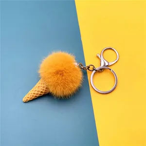 Cute yellow plush pom pom ice cream cone keychain bag charm on blue and yellow background