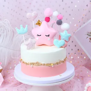 Dettaglio di topper per torta in tessuto rosa e blu a forma di corona e stella.