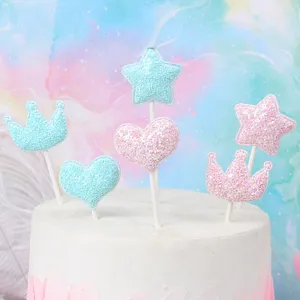 Primo piano di topper per torta luccicanti a forma di cuore, stella e corona in pastello.