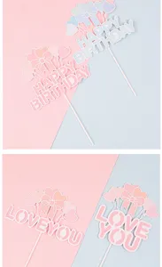 Detailopname van taarttoppers met hartjes en strikjes, Happy Birthday en Love You tekst.