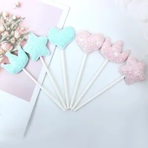 Decorazioni per torte in tessuto glitterato rosa e blu con forme cuore stella e corona.