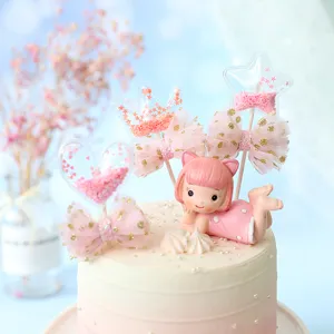 Detailed view of pink sequin heart and star cake toppers with a girl figurine.