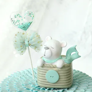 Detailed close-up of a cute white bear and teal heart cake topper decoration