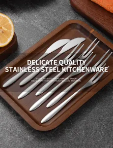 Detailed macro view of premium stainless steel fruit forks and knives on a wooden tray