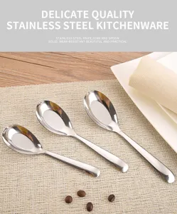 Dettaglio di cucchiai ovali in acciaio inossidabile lucidato su una tovaglietta.