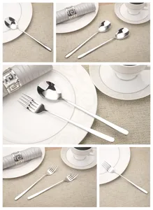 Detailed view of polished stainless steel spoons and forks set on a stylish dining table.