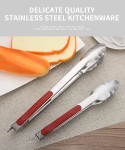 Detailed view of two stainless steel food tongs with red handles on a dining mat
