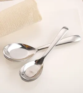 Dettaglio di due cucchiai in acciaio inossidabile con finitura a specchio e forma ovale.