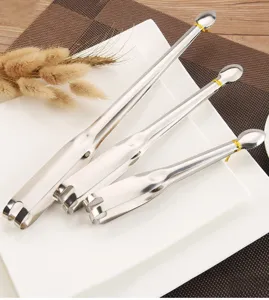 Set of three stainless steel food tongs in different sizes on a white plate