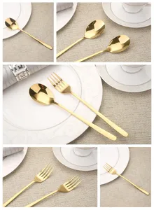 Detailed view of elegant golden stainless steel spoon and fork set on white dinnerware