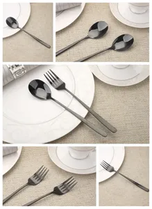 Macro detail of elegant matte black stainless steel spoon and fork on white plate