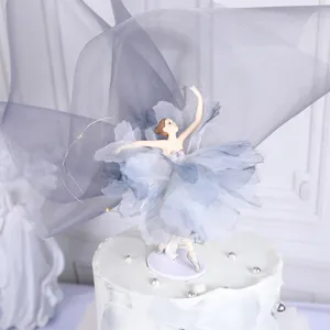 Elegante balletmeisje taarttopper met blauwe tutu op een witte taart met parels