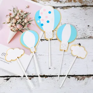 Primo piano di decorazioni per torte a forma di mongolfiera blu e nuvola bianca