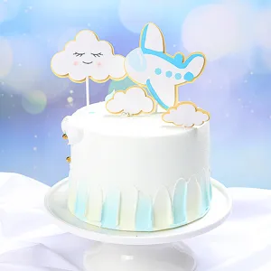 Dettaglio di decorazioni per torte a forma di aereo e nuvole su una torta