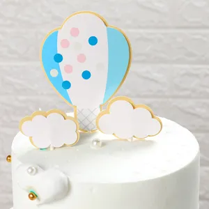 Vista dettagliata di un set di decorazioni per torta con mongolfiera e nuvole su torta bianca