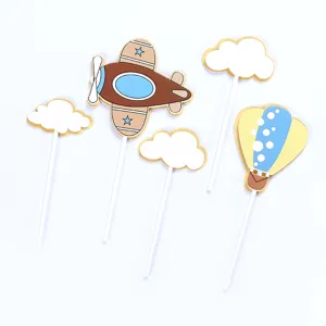 Set di decorazioni per torte con aereo, mongolfiera e nuvole su uno sfondo bianco