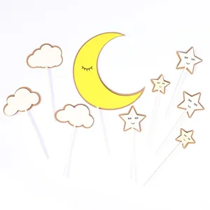 Detail view of yellow moon and star cake toppers for birthday party decorations