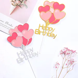 Detail view of gold and silver heart balloon cake toppers with glitter Happy Birthday.