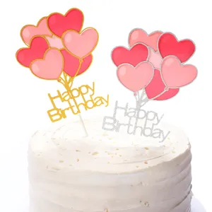 Close-up of gold and silver glitter Happy Birthday heart balloon cake toppers