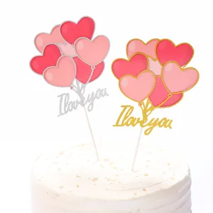 Macro view of pink heart balloon cake toppers with I Love You gold glitter text