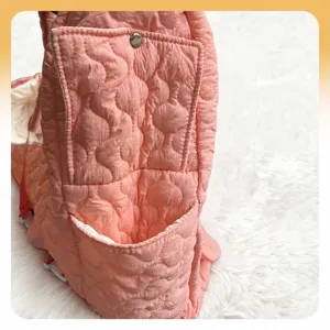 Pink quilted pet backpack carrier detail view with side storage pocket for small cats and dogs.