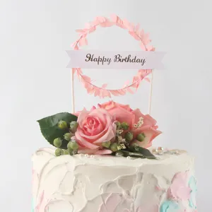 Detailed view of forest style pink leaf wreath cake topper with Happy Birthday ribbon