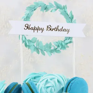 Close-up detail of green leaf wreath birthday cake topper with Happy Birthday banner