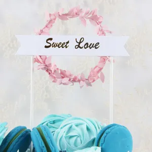 Close-up detail of romantic pink wreath cake topper with Sweet Love banner decoration