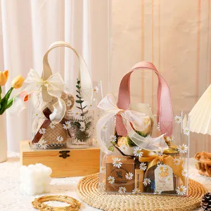 Detalle de la bolsa de regalo transparente con estampado de margaritas y asa rosa