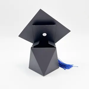 Gros plan d'une boîte cadeau en forme de toque noire avec pompon bleu pour fêtes
