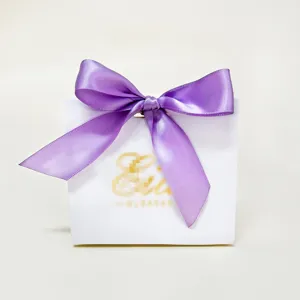 Detail van een witte Eid Mubarak geschenkdoos met een elegante paarse satijnen strik