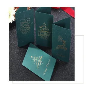 Primer plano de elegantes tarjetas navideñas verde oscuro con finos diseños dorados