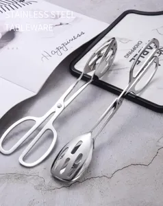 Detail view of two stainless steel scissor-style slotted food tongs for salad and BBQ