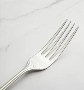 Primo piano di elegante forchetta in acciaio inox 304 con manico vintage goffrato