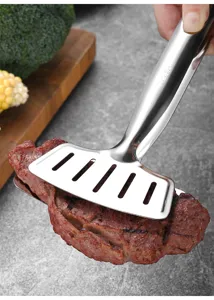 Detalle de pinzas de cocina de acero inoxidable 304 volteando un jugoso filete a la parrilla