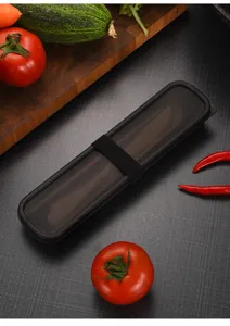 Sleek black portable cutlery storage case with elastic strap shown with fresh vegetables