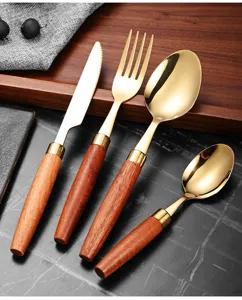 Detailaufnahme eines 4-teiligen goldfarbenen Bestecksets mit Griffen aus edlem Sapele-Holz.