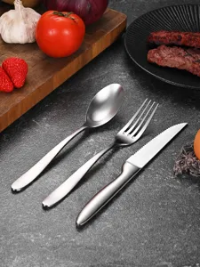 Close-up of 3-piece stainless steel cutlery set with brushed finish on dark countertop