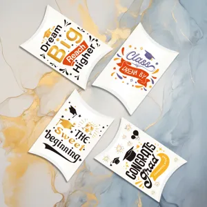 Set of four graduation themed white pillow candy boxes with festive gold and black prints