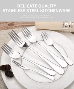 Detailed macro view of various stainless steel dinner and dessert forks arranged on a white plate