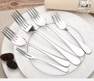 Detailed view of high-quality stainless steel forks set on a white ceramic plate