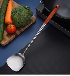 Primer plano detallado de la textura de acero inox SUS304 y el mango de madera de la espátula.