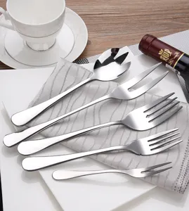Close-up detail of various stainless steel serving forks and dessert forks set on a napkin